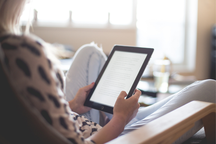 Una ragazza impegnata a leggere un ebook su come aprire un blog di libri e guadagnarci